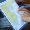  Các ngư dân tìm hiểu kỹ sơ đồ vùng biển Việt Nam để không vi phạm lãnh hải nước khác trong quá trình khai thác thủy sản. (Ảnh: Quốc Dũng/TTXVN)