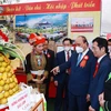Chủ tịch nước Nguyễn Xuân Phúc và các đại biểu tham quan Triển lãm thành tựu kinh tế-xã hội tỉnh Lạng Sơn năm 2021.(Ảnh: Thống Nhất/TTXVN)