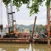 Một đơn vị chuẩn bị phương tiện để triển khai xây dựng kè và đường giao thông dọc bờ sông Cái Nha Trang trong khuôn khổ dự án. (Ảnh: Tiên Minh/TTXVN)