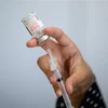 Nhân viên y tế chuẩn bị mũi tiêm vaccine ngừa COVID-19. (Ảnh: AFP/TTXVN)