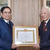 Thủ tướng Phạm Minh Chính trao Huy hiệu 60 năm tuổi Đảng tặng ông Vũ Khoan. (Ảnh: TTXVN phát)
