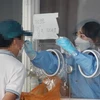 Nhân viên y tế lấy mẫu xét nghiệm COVID-19 cho người dân tại Hàn Quốc. (Ảnh: Yonhap/TTXVN)