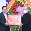 Thủ tướng Phạm Minh Chính tặng quà chúc mừng Giáng sinh giáo dân giáo xứ Long Hưng. (Ảnh: Dương Giang/TTXVN)