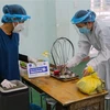 Nhân viên y tế chuẩn bị các dụng cụ y tế cần thiết để đến tận nhà tiêm vaccine phòng COVID-19 cho người già yếu. (Ảnh: Trần Lê Lâm/TTXVN)