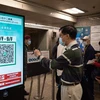 Người dân quét mã kiểm tra y tế trước khi vào tòa nhà tại Hong Kong, Trung Quốc, ngày 9/12/2021. (Ảnh: AFP/TTXVN)