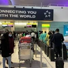 Hành khách hồ hởi chờ làm thủ tục lên máy bay của Vietnam Airlines tại sân bay Heathrow để về Việt Nam đón tết Nguyên đán Nhâm Dần. (Ảnh: Đình Thư/Vietnam+)