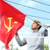 Người dân treo cờ trên tuyến đường chính của xã Cư Mgar, huyện Cư Mgar, tỉnh Đắk Lắk. (Ảnh: Tuấn Anh/TTXVN)