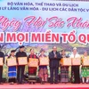 Chủ tịch nước Nguyễn Xuân Phúc tặng quà đồng bào dân tộc tại Làng Văn hóa-Du lịch các dân tộc Việt Nam. (Ảnh: Tuấn Đức/TTXVN)
