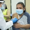 Nhân viên y tế tiêm vaccine phòng COVID-19 cho một phụ nữ tại New York, Mỹ. (Ảnh: AFP/TXVN)