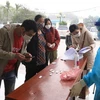 Người dân mang bộ kit đến xét nghiệm ở Trạm y tế lưu động số 1 xã Tân Triều, huyện Thanh Trì. (Ảnh: Hoàng Hiếu/TTXVN)
