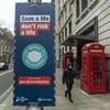 Biển hiệu khuyến khích người dân đeo khẩu trang phòng dịch COVID-19 tại London, Anh. (Ảnh: THX/TTXVN)
