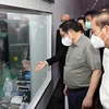 Thủ tướng Phạm Minh Chính xem quy trình chế biến thịt gia cầm xuất khẩu của Công ty trách nhiệm hữu hạn CPV Food. (Ảnh: Dương Giang/TTXVN)