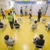 Người dân xếp hàng chờ tiêm vaccine phòng COVID-19 tại Nagoya, Nhật Bản. (Ảnh: AFP/TTXVN)
