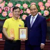 Chủ tịch nước Nguyễn Xuân Phúc tặng chân dung Chủ tịch Hồ Chí Minh cho đoàn viên thanh niên tiêu biểu. (Ảnh: Thống Nhất/TTXVN)