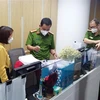 Lực lượng chức năng khám xét và thu giữ tài liệu tại trụ sở FLC hôm 29/3. (Ảnh: Phạm Kiên/TTXVN)