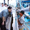 Thủ tướng Phạm Minh Chính thăm hỏi, động viên ngư dân tàu cá đang neo đậu tại cảng cá xã Cà Ná. (Ảnh: Dương Giang/TTXVN)