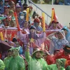 Cổ động viên Việt Nam đội mưa cổ vũ cho các cầu thủ đội U23 Việt Nam. (Ảnh: Minh Quyết/TTXVN)