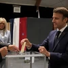 Tổng thống Pháp Emmanuel Macron (phải) bỏ phiếu bầu cử Quốc hội vòng hai tại Le Touquet ngày 19/6. (Ảnh: AFP/TTXVN)