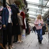 Người dân mua sắm tại một khu chợ ở London, Anh. (Ảnh: AFP/TTXVN)