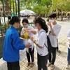  Thanh niên tình nguyện xã Minh Tân cung cấp nước mía miễn phí cho thí sinh và người nhà thí sinh. (Ảnh: TTXVN phát)