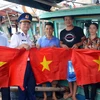 Tặng cờ Tổ quốc cho bà con ngư dân huyện Cát Hải. (Ảnh: Minh Huệ/TTXVN)