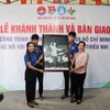 Đại diện Cơ quan thường trú TTXVN tại Thành phố Hồ Chí Minh tặng bức ảnh Chủ tịch Hồ Chí Minh cho Ủy ban Nhân dân xã Nhuận Đức. (Ảnh: Thu Hương/TTXVN)