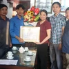 Lãnh đạo Ủy ban Nhân dân huyện Hải Hậu trao Giấy khen cho em Bùi Hải An (thứ 2, từ trái sang). (Ảnh: TTXVN phát)