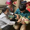 Cán bộ Trạm Y tế xã Dà Sề Phìn ở huyện Sìn Hồ (Lai Châu) tuyên truyền người dân đến trạm y tế khi sinh nở và hướng dẫn chăm sóc trẻ. (Ảnh: Việt Hoàng/TTXVN)