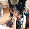 Nhân viên y tế tiêm vaccine phòng COVID-19 cho trẻ 5-12 tuổi tại xã Tà Tổng, Mường Tè, Lai Châu. (Ảnh: Nhật Anh/TTXVN)