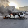 Ôtô bị đốt cháy trong các vụ đụng độ tại Tripoli, Libya, ngày 27/8. (Ảnh: THX/TTXVN)