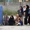 Phụ nữ và trẻ em Afghanistan xếp hàng chờ nhận lương thực cứu trợ tại Kabul. (Ảnh: THX/TTXVN)