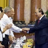 Chủ tịch nước Nguyễn Xuân Phúc với các cán bộ từng phục vụ và bảo vệ Bác Hồ. (Ảnh: Thống Nhất/TTXVN)