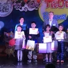 Đại sứ Việt Nam tại Hungary Nguyễn Thị Bích Thảo trao thưởng cho các cháu học sinh trong cộng đồng người Việt. (Ảnh: TTXVN phát)