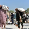 Người dân nhận lương thực cứu trợ tại Kandahar, Afghanistan. (Ảnh: THX/TTXVN)