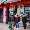 Người dân di chuyển trên một phố mua sắm ở London, Anh. (Ảnh: AFP/TTXVN)