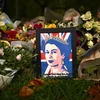 Người dân đặt hoa tưởng niệm Nữ hoàng Elizabeth II tại London, Anh. (Ảnh: AFP/TTXVN)