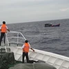 Tàu Hải quân 473 lai kéo tàu cá QNg 90379TS về đảo Song Tử Tây. (Ảnh: TTXVN phát)