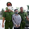 Lực lượng chức năng dẫn giải bị cáo Nguyễn Trung Huyên đến phiên tòa xét xử. (Ảnh: Phạm Kiên/TTXVN)