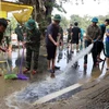 Các lực lượng tham gia dọn dẹp bùn non sau khi nước lũ rút tại nhiều tuyến đường của thành phố Huế. (Ảnh: Đỗ Trưởng/TTXVN)