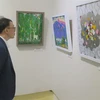 Du khách Hàn Quốc xem tranh trưng bày tại triển lãm. (Ảnh: TTXVN phát)