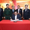 Thủ tướng Phạm Minh Chính viết lưu bút sau khi thăm Phòng truyền thống Hội Cựu chiến binh Việt Nam. (Ảnh: Dương Giang/TTXVN)