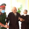 Bị cáo Lê Tùng Vân được cảnh sát dìu đến tòa ngày 20/7. (Ảnh: Bùi Giang/TTXVN)