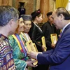 Chủ tịch nước Nguyễn Xuân Phúc tặng chân dung Chủ tịch Hồ Chí Minh cho đại biểu người có uy tín tiêu biểu tỉnh Hà Giang. (Ảnh: Thống Nhất/TTXVN)