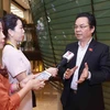 Phóng viên phỏng vấn đại biểu Quốc hội thành phố Hà Nội Hoàng Văn Cường bên hành lang Quốc hội. (Ảnh: Doãn Tấn/TTXVN)