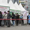 Người dân xếp hàng chờ xét nghiệm COVID-19 tại Seoul, Hàn Quốc. (Ảnh: AFP/TTXVN)