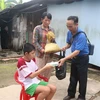 Thầy Lê Trung Lành đến tận nhà trao quà cho các trẻ em có hoàn cảnh đặc biệt khó khăn. (Ảnh: Lê Thúy Hằng/TTXVN)