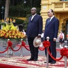 Chủ tịch nước Nguyễn Xuân Phúc và Tổng thống Uganda Yoweri Kaguta Museve nghe quân nhạc cử Quốc thiều hai nước. (Ảnh: Thống Nhất/TTXVN)