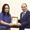 Chủ tịch nước Nguyễn Xuân Phúc tặng ảnh Chủ tịch Hồ Chí Minh cho dịch giả trẻ Nguyễn Bình. (Ảnh: Thống Nhất/TTXVN)
