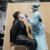 Nhân viên y tế lấy mẫu xét nghiệm COVID-19 tại Narita, Nhật Bản. (Ảnh: AFP/TTXVN)
