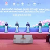 Thủ tướng Phạm Minh Chính và các đại biểu bấm nút khai mạc Triển lãm Quốc phòng quốc tế Việt Nam 2022. (Ảnh: Dương Giang/TTXVN)